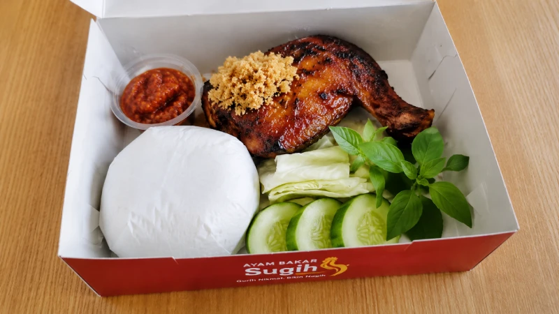 Isi nasi box ayam bakar Sugih lengkap dengan lalapan dan sambal